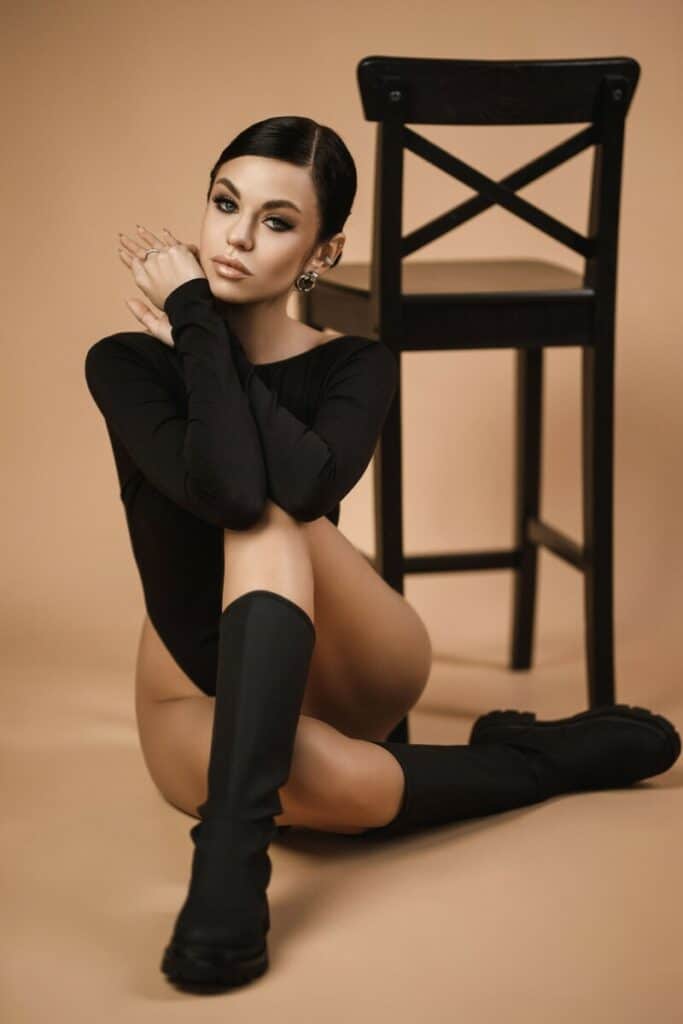 Sexy dark hair woman sitting next to the chair